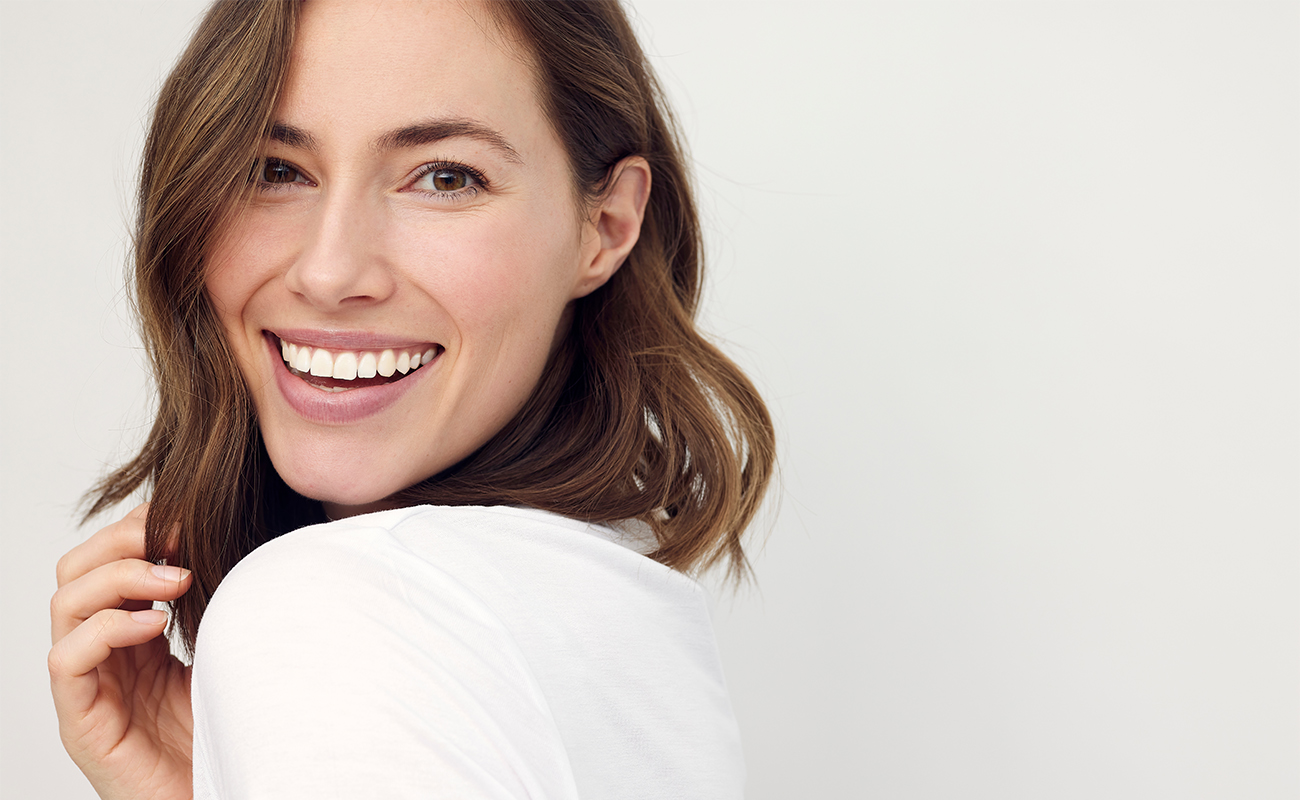 Brunette woman smiling over her shoulder