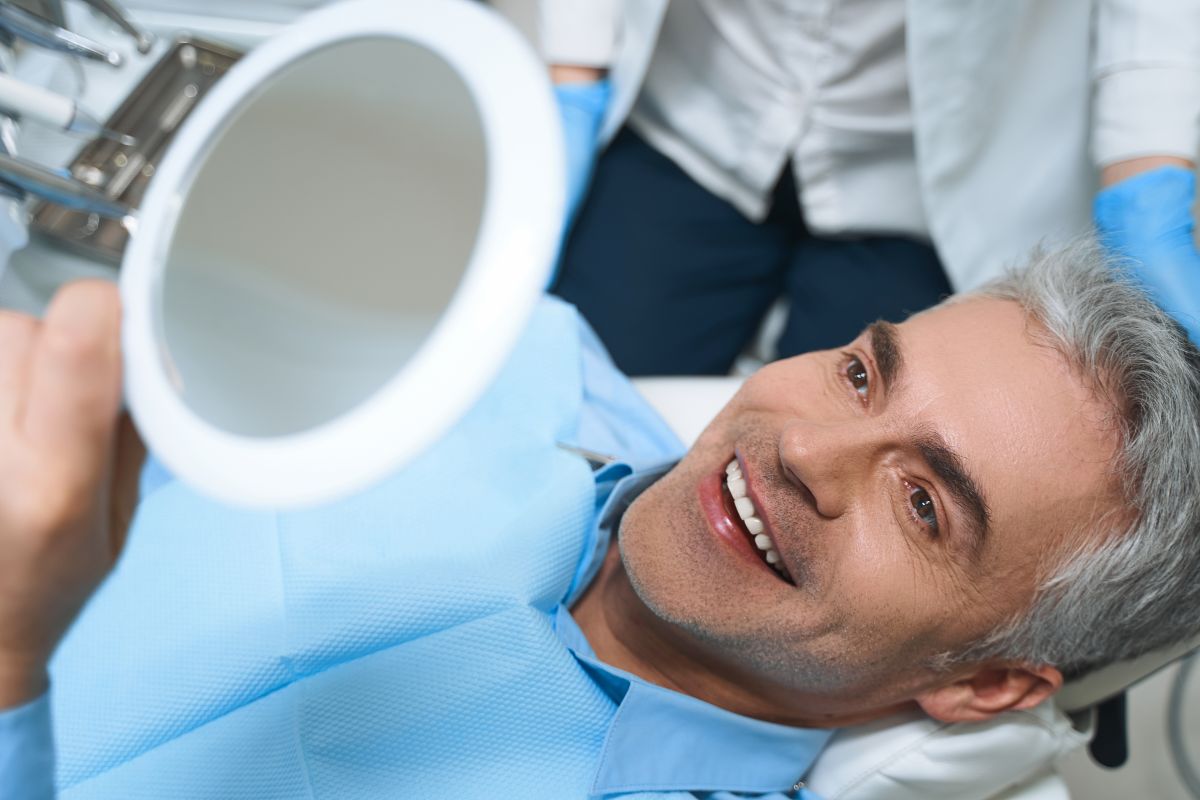 A man looking in the mirror at his dental implants